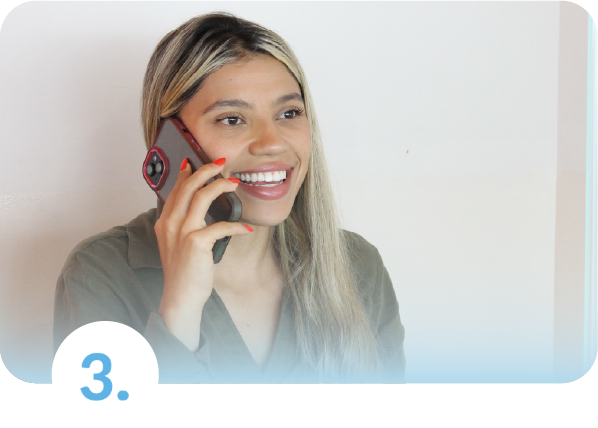 Primer plano de una mujer joven sonriente hablando por teléfono móvil, representando la tranquilidad de un cliente al recibir asesoría y acompañamiento en su seguro de salud.
