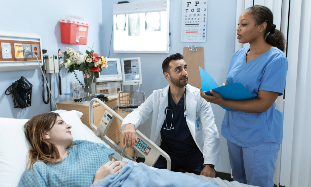 Paciente joven hospitalizada en una clínica conversando con su médico y enfermera, representando el respaldo de un seguro de salud ante emergencias médicas en Colombia.