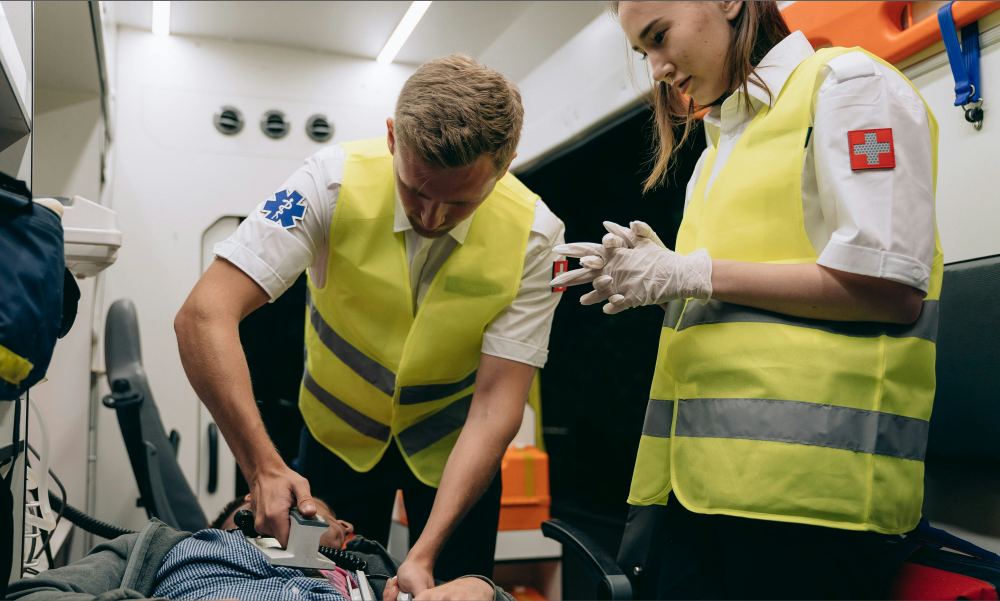Paratripulantes de ambulancia atendiendo una emergencia médica crítica a bordo, ejemplificando la cobertura de urgencias e imprevistos en un seguro de salud en Colombia.