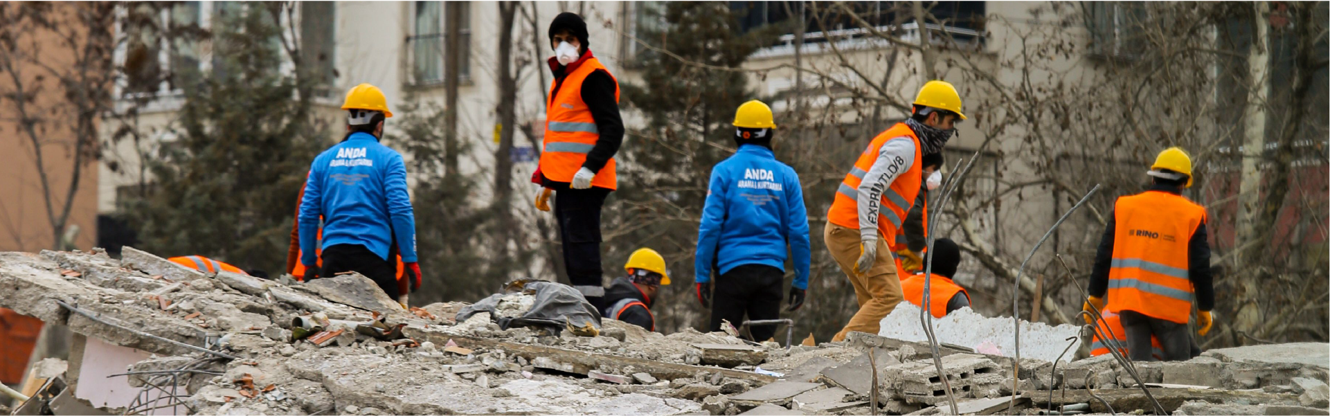 Equipo de rescate trabajando sobre los escombros de un edificio colapsado tras un desastre natural.
