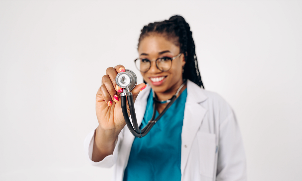 Doctora afrocolombiana sosteniendo un estetoscopio hacia la cámara, representando la protección en salud, invalidez y seguro de vida en Colombia.