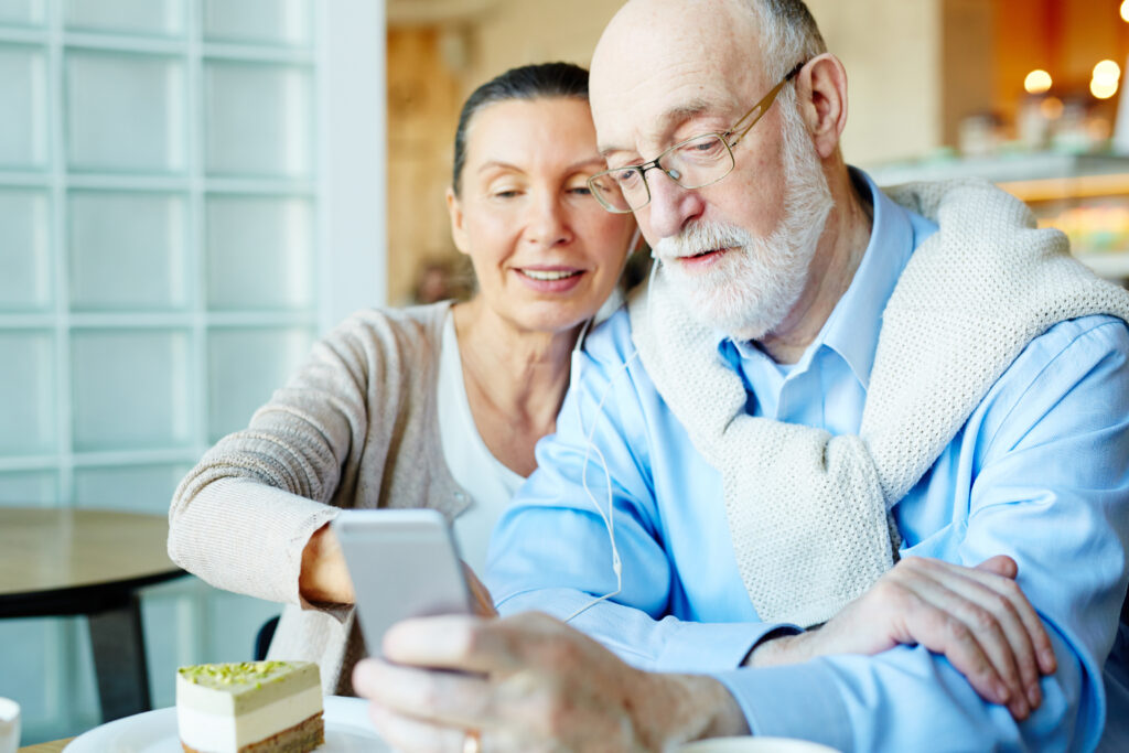 pareja de adultos mayores viendo un celular
