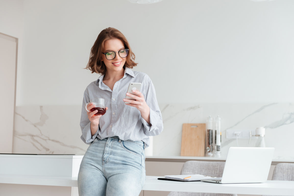 Mujer feliz revisando desde su celular los beneficios de su Seguro de Salud Digital Seguro de Salud Digital Todos los beneficios al alcance de tu mano
