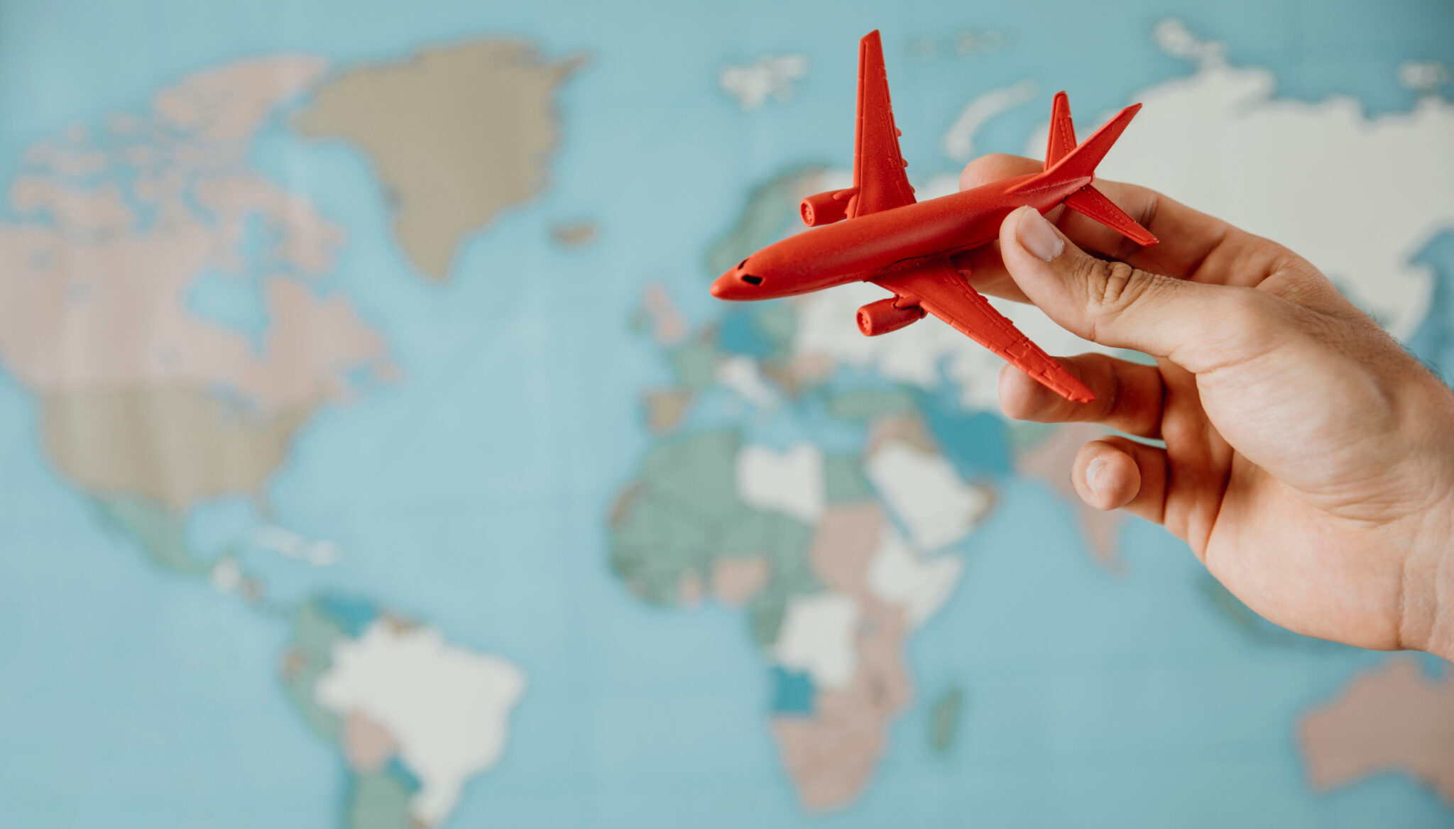 Seguro de Viajes Digital - Una mano sosteniendo un avión de juguete