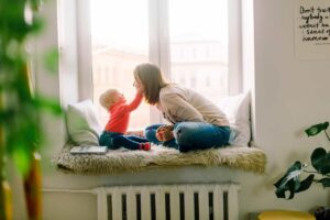 madre e hijo sentados al lado de una ventana