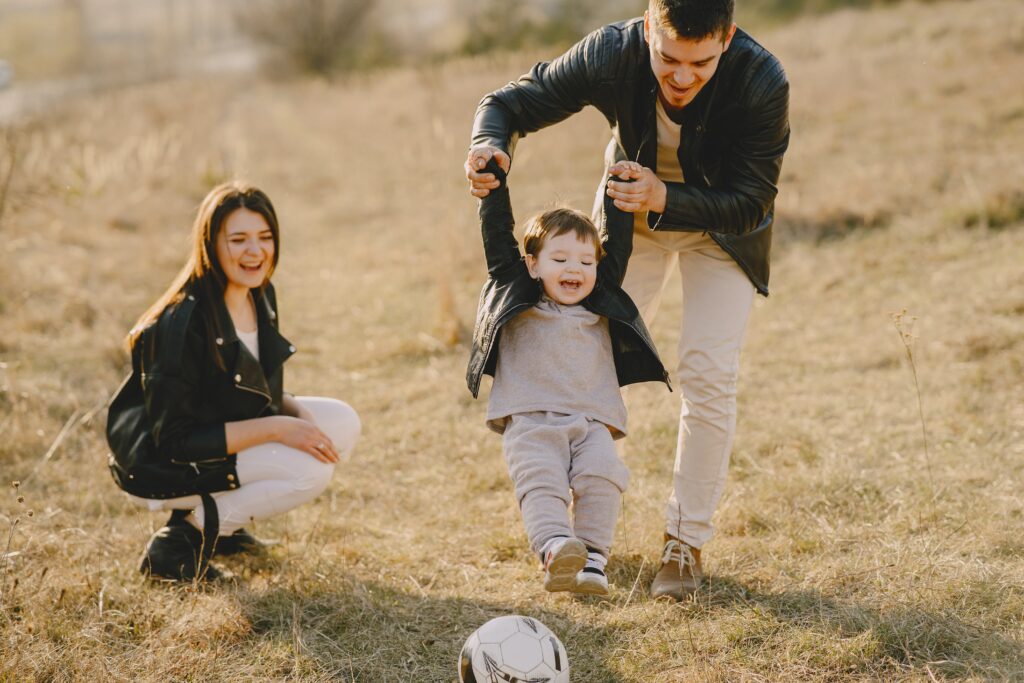 padre y madre llevando a su hijo a jugar